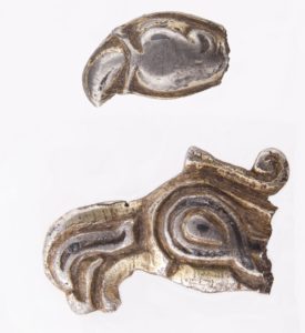 Główki ptaków drapieżnych – fragmenty wczesnośredniowiecznych trzewików pochew mieczy, znalezione na stokach grodziska w Szurpiłach. Fot. M. Bajkowska